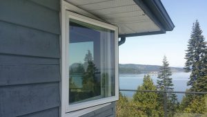 Open window with a view of a forested area and Pacific Ocean 
